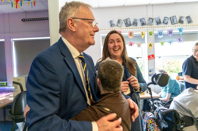 The Health Minister Mike Nesbitt is hugged by one of the service users at Antrim Adult Centre.