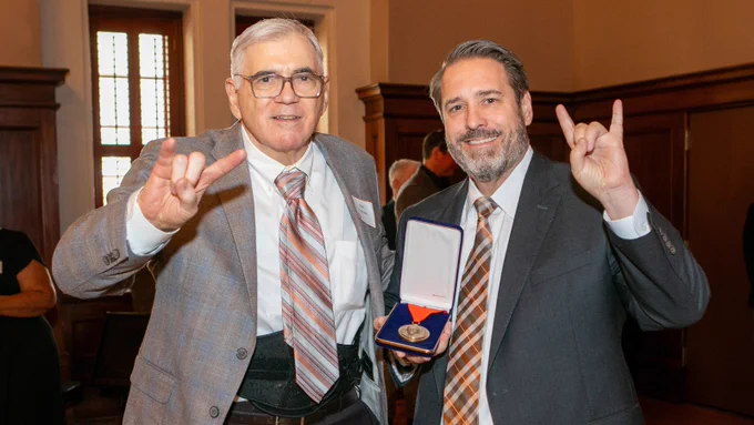Bob Childress and President Jim Davis at the award ceremony. Bob is holding his Arno Nowotny Medal, and they both are doing the Hook ‘em sign.