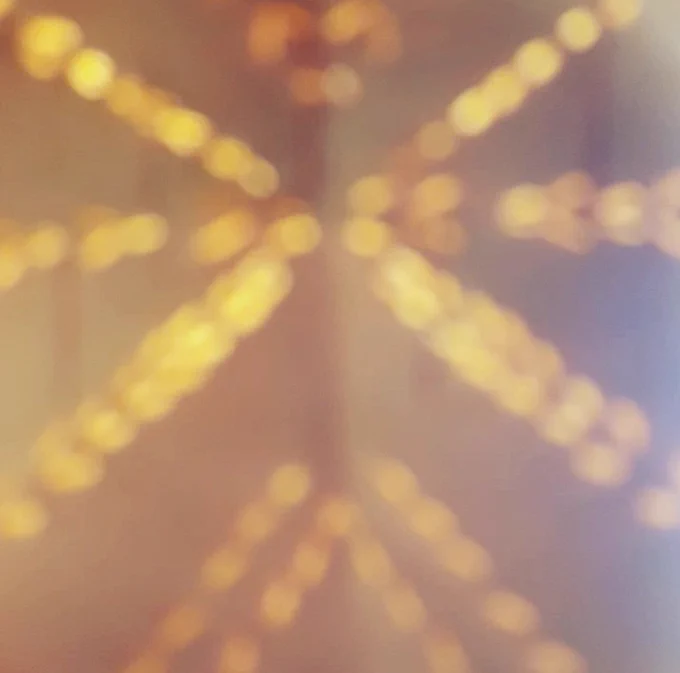 Soft golden lights arranged in a symmetrical starburst pattern against a blurred warm background.