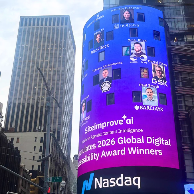 The same Nasdaq billboard in Times Square photographed from street level, showing the award winners' headshots and the Siteimprove.ai congratulatory message against a blue-to-purple gradient. A New York City skyscraper rises in the background.