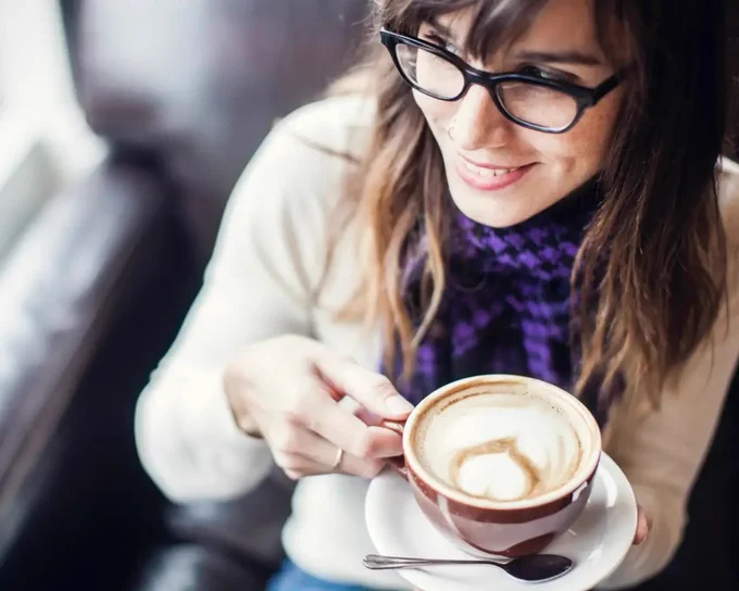 Model wearing glasses having coffee