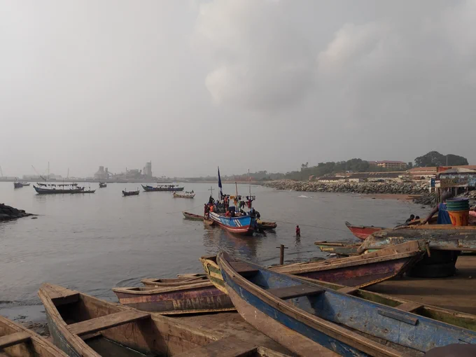 Fishers guide their canoe across a foggy harbor. Image credit: Adelina Mensah