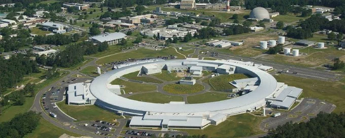 Aerial view of the NSLS-II, which looks like a large white ring surrounded by lawn and buildings