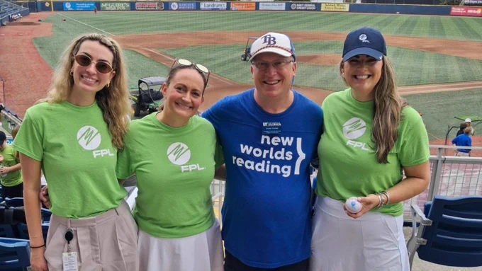 Four people standing in front of a baseball stadium.
