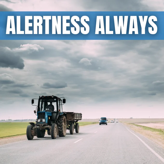 Image of a blue tractor on a rural road followed by a car behind it. A large banner at the top reads Alertness as Always.