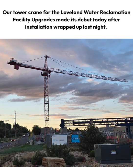 A large tower crane is positioned at the Loveland Water Reclamation Facility. The crane is prominently set against a cloudy sky during evening light. Text reads: Our tower crane for the Loveland Water Reclamation Facility Upgrades made its debut today after installation wrapped up last night.