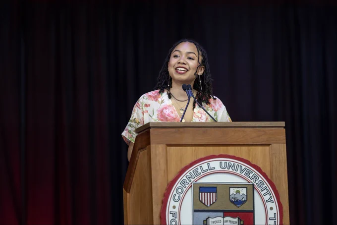 The senior speaker during the 2026 Cornell Senior Convocation at a podium with the Cornell seal.