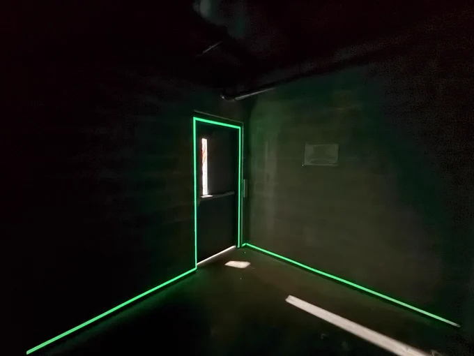 Photograph of perimeter markings leading to final exit door at the bottom of a high-rise stairwell installed in May 2026. Copyright Luminous Egress of Chandler, Arizona. All rights reserved.