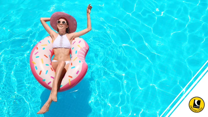Person in swimming pool smiling on inflatable. ATOL logo in bottom right
