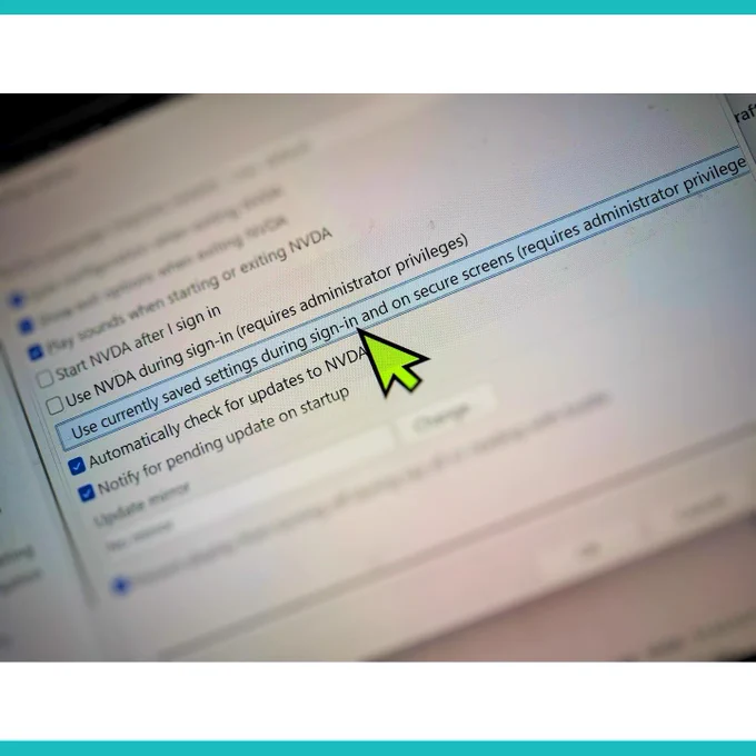 Photograph of the NVDA General Settings with the mouse pointer hovering over the "Use Currently Saved settings during sign in and on secure screens" button.  White and turquoise stripes top and bottom to make a square image.