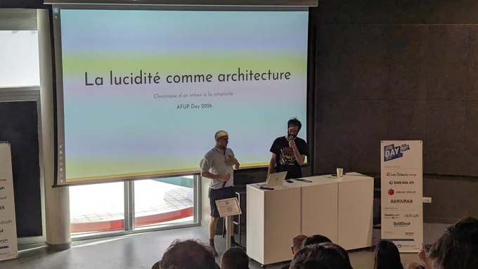 Two speakers discuss architectural insights at AFUP Day 2026, with a presentation projected on screen in front of an audience.