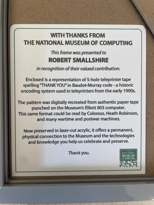 WITH THANKS FROM
THE NATIONAL MUSEUM OF COMPUTING
This frame was presented to
ROBERT SMALLSHIRE
in recognition of their valued contribution.
Enclosed is a representation of 5-hole teleprinter tape spelling "THANK YOU" in Baudot-Murray code - a historic encoding system used in teleprinters from the early 1900s.
The pattern was digitally recreated from authentic paper tape punched on the Museum's Elliott 803 computer.
This same format could be read by Colossus, Heath Robinson, and many wartime and postwar machines.
Now preserved in laser-cut acrylic, it offers a permanent, physical connection to the Museum and the technologies and knowledge you help us celebrate and preserve.
Thank you.