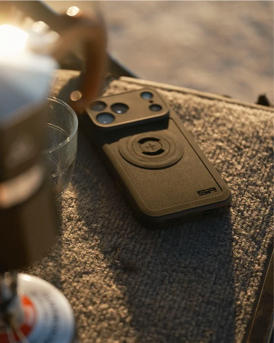 A smartphone case with a camera, flashlight, and other features on a textured surface.