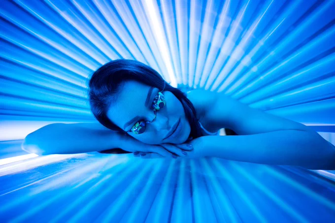 Teenager using a sunbed