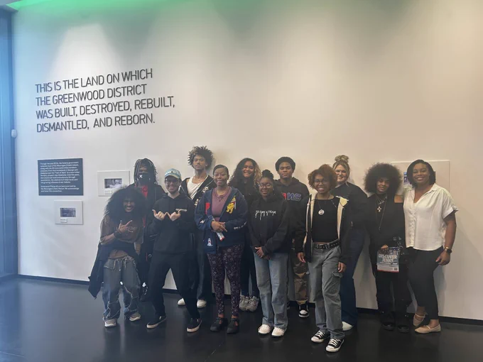 Eleven students and their advisor take a photo at Greenwood Rising.
