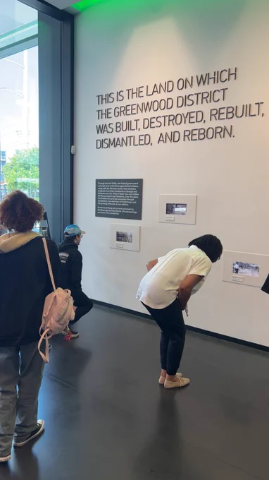 Students are looking at photos inside Greenwood Rising.