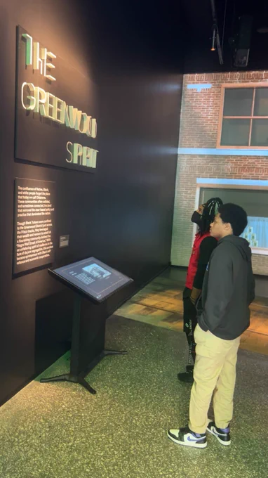 Students are looking at panels in Greenwood Rising.