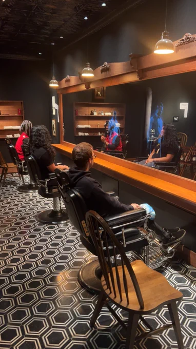 Students are sitting in barbershop chairs inside Greenwood Rising's interactive exhibition.