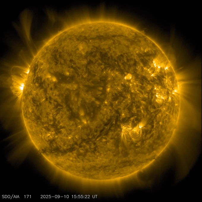The Sun seen by SDO. A bright flash of a solar flare glows on the Sun's right side, near 3 o’clock. The Sun appears golden yellow, with darker mottled patches, and brighter swirls on its surface.