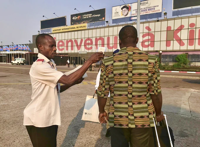 An airport employee screens a man entering the airport in the Democratic Republic of Congo for Ebola.