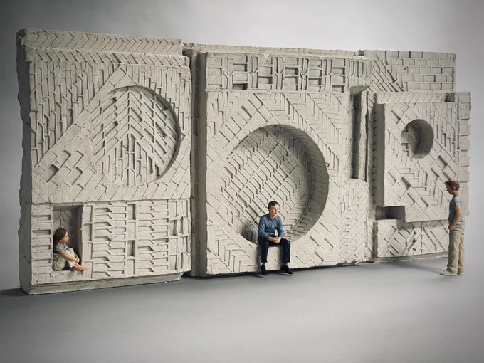A model of a sculpture made out of clay, with an adult and child sitting within