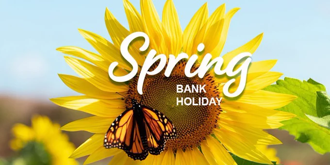 Bright yellow sunflower in full bloom under a blue sky, with a monarch butterfly resting on the flower’s centre. White text overlaid on the image reads “Spring” with “Bank Holiday” beneath.
