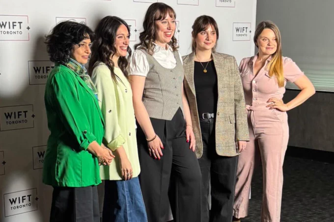 A group of women in front of a backdrop.