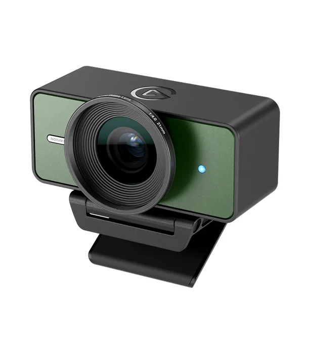 Black webcam with a large central lens, green front panel, blue indicator light, and clip mount on a white background.
