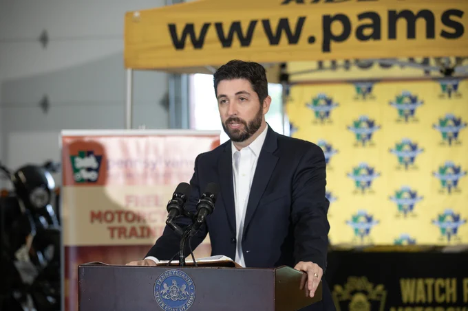 Pennsylvania Deputy Insurance Commissioner Richard Hendrickson stands at a podium to speak about insurance and safety for motorcyclists. 