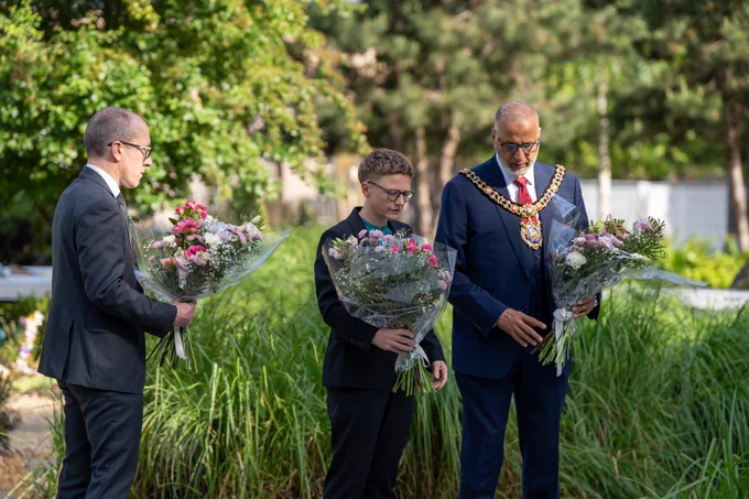 The Lord Mayor, wearing his mayoral chains, the Leader of the Council, and the Chief Executive of Manchester Council each hold a bunch of flowers to lay at the Glade of Light in memory of those who lost their lives in the Manchester Arena Attack on 22nd May 2017.