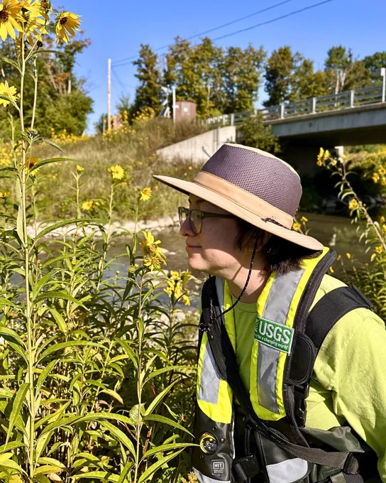 Stopping to smell the flowers during routine water quality sampling at Canajoharie Creek, New York. The gage, visible in the background, is part of the USGS NQWN sampling network. Photo by Sabina Gifford, USGS