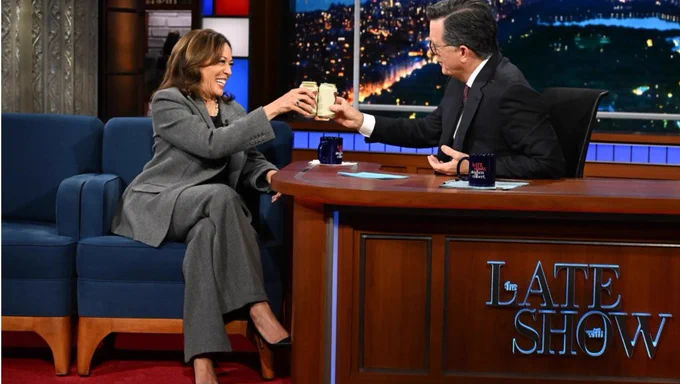 An image of Kamala Harris and Stephen Colbert toasting a can of beer on "The Late Show."