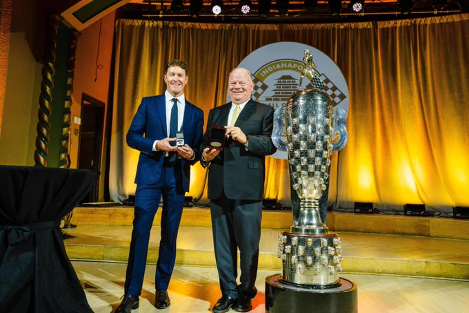 Scott Dixon and Chip Ganassi pose and smile on stage