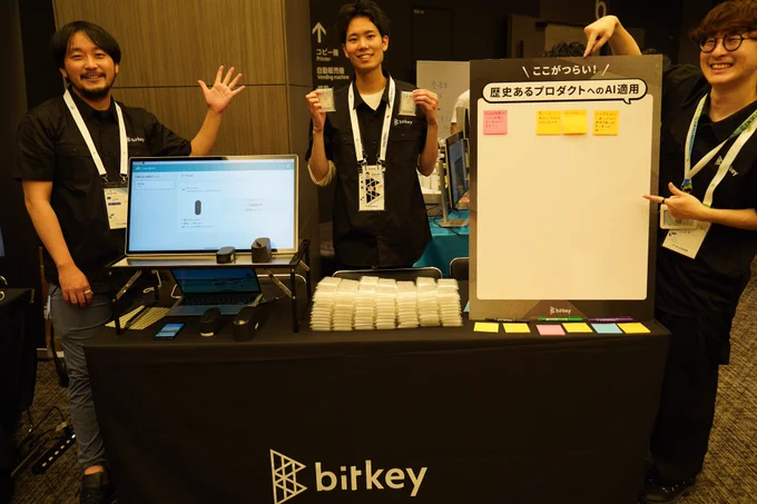 ビットキー社のブース写真
歴史あるプロダクトへのAI適用というパネルやディスプレイが並べられたブースで3名の男性が笑顔で写真に写っている