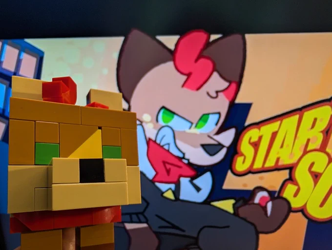A minecraft inspired Lego model, depicting Yotemotes character. The model is looking at the viewer, having the starting soon screen of Yotemotes with said character in the background.