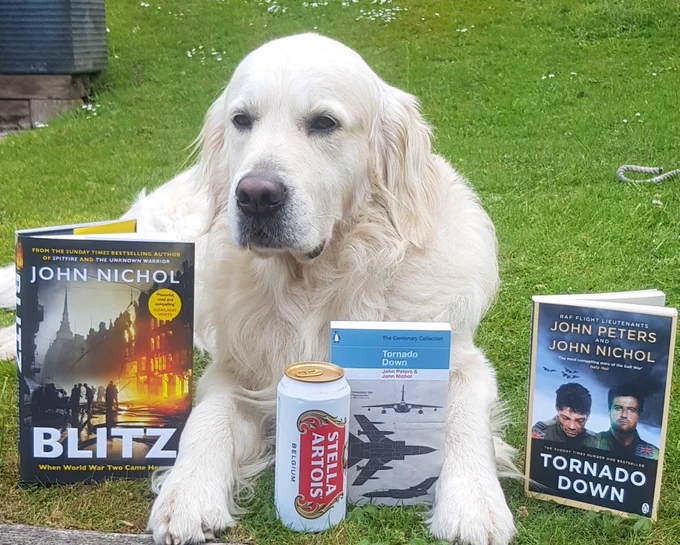 Ralph the golden retriever with a can of Stella lager and the books.