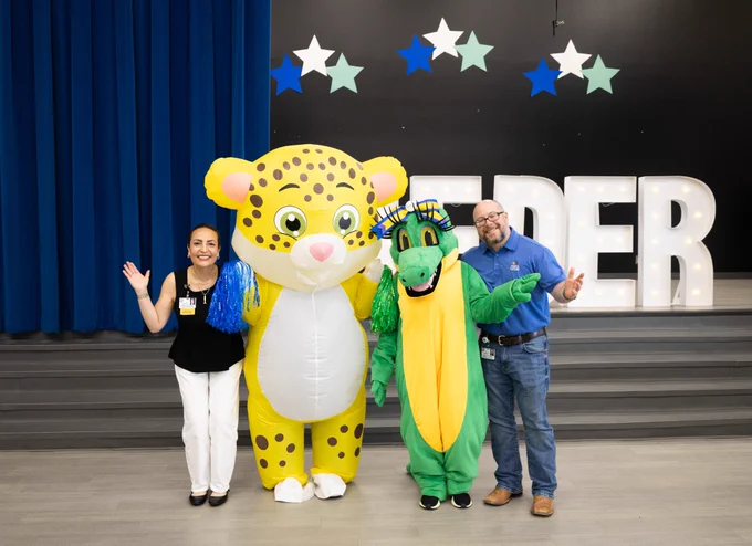 Some of the community programs team poses for a photo with the leopard mascot of Lieder Elementary and Allie the Alligator.