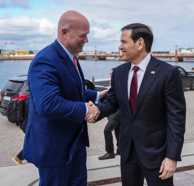 Secretary Rubio shakes hands with U.S. Ambassador to NATO Matthew G. Whittaker in Helsingborg, Sweden on May 22, 2026. Cars, a bridge, and a river are visible behind them. (State Department/Freddie Everett)