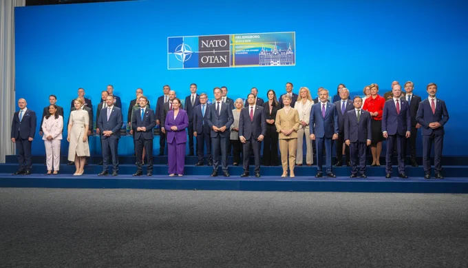 Secretary Rubio stands on a raised platform stage with other foreign ministers from NATO countries to post in a group photo in Helsingborg, Sweden on May 22, 2026. The group stands in front of a backdrop with the NATO emblem in the middle. (State Department/Freddie Everett)