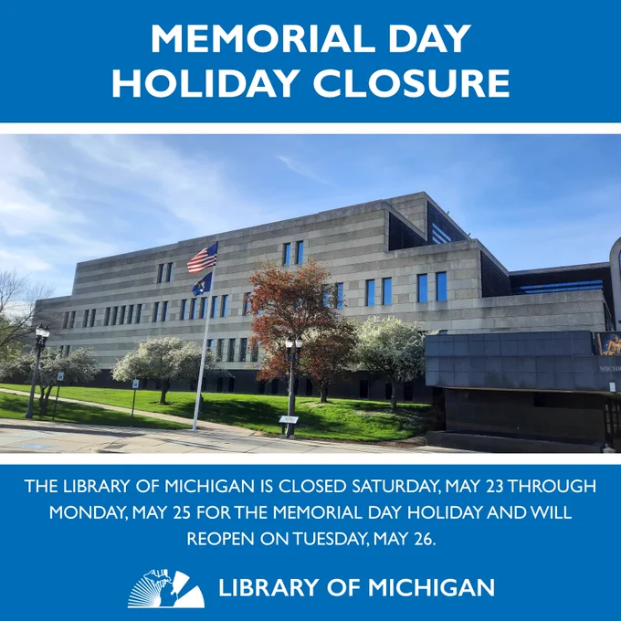 Exterior of the Library of Michigan on a sunny afternoon with the US and Michigan flags waving.