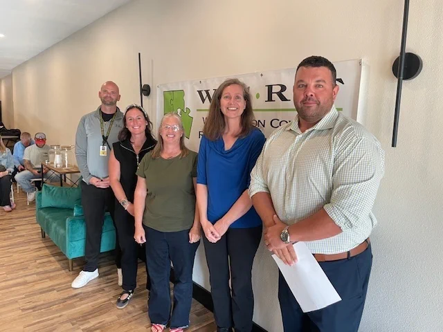 WCRF Representative smiling with Cate Burke, Jana Stout, Robin Foster, and Tim Bartels