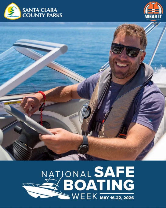 A graphic of a male boater in a life jacket with the Engine Cut-Off Switch to his wrist in the driver seat of a boat on the water. The text reads – National Safe Boating Week May 16-22, 2026.