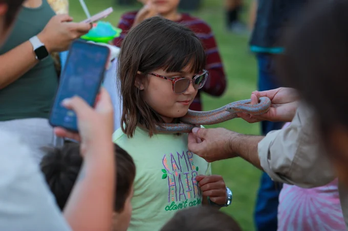A child with a snake around neck.