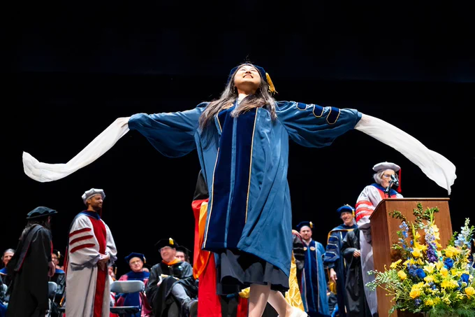 Ph.D. graduate Zhe Fu unfurls Chinese silk sleeves onstage at Zellerbach before being hooded. (Photo by Adam Lau/UC Berkeley Engineering)
