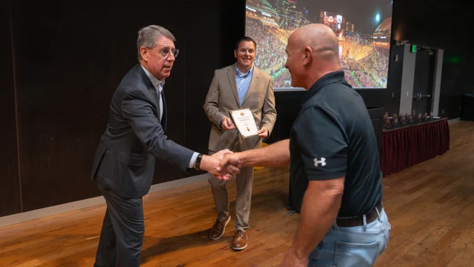ASU Executive Vice President, Treasurer and Chief Financial Officer Morgan R. Olsen congratulates an FDM employee during Arizona State University's FDM Employee Recognition event in May.