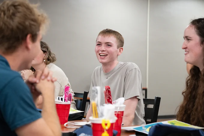 Joshua Stewart laughs while talking to other Residence Life student staff.