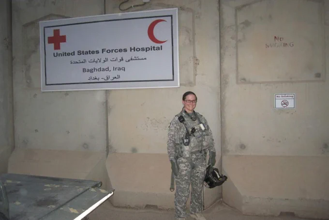 A photo of FSU student Allison Justice in a military uniform standing in front of the United States Forces Hospital in Baghdad, Iraq.