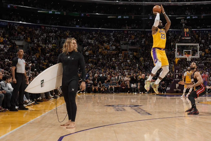 No meio de uma partida lotada da NBA, parece que um surfista entrou na arena achando que a próxima série estava quebrando ali mesmo. 🏄‍♂️🏀😂

Enquanto o jogador sobe para um arremesso decisivo e toda a torcida acompanha o lance em tensão máxima, o surfista permanece completamente tranquilo segurando sua prancha, como se estivesse esperando a próxima onda perfeita aparecer na quadra. 

O contraste entre o caos do esporte e a calma do surf cria uma cena totalmente surreal e engraçada.

#SurfHumor #BasketSurf #NBA #SurfCulture #SurrealArt #SportsArt #SurfLife #Humor #Crossover #WaveHunter