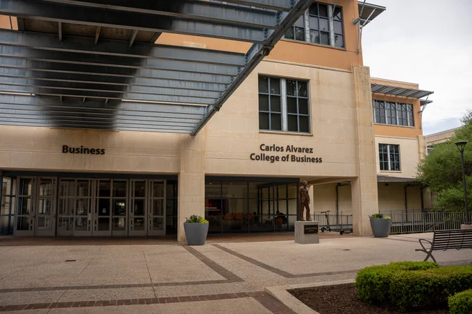 Entrance of Carlos Alvarez College of Business with large windows and a covered walkway.