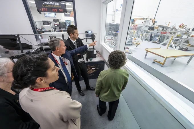 Bobby Braun (left), head of APL’s Space Exploration Sector, discussing the first-of-its-kind Dragonfly vehicle with Isaacman outside of the Lab’s clean rooms. (Credit: Johns Hopkins APL/Craig Weiman)
